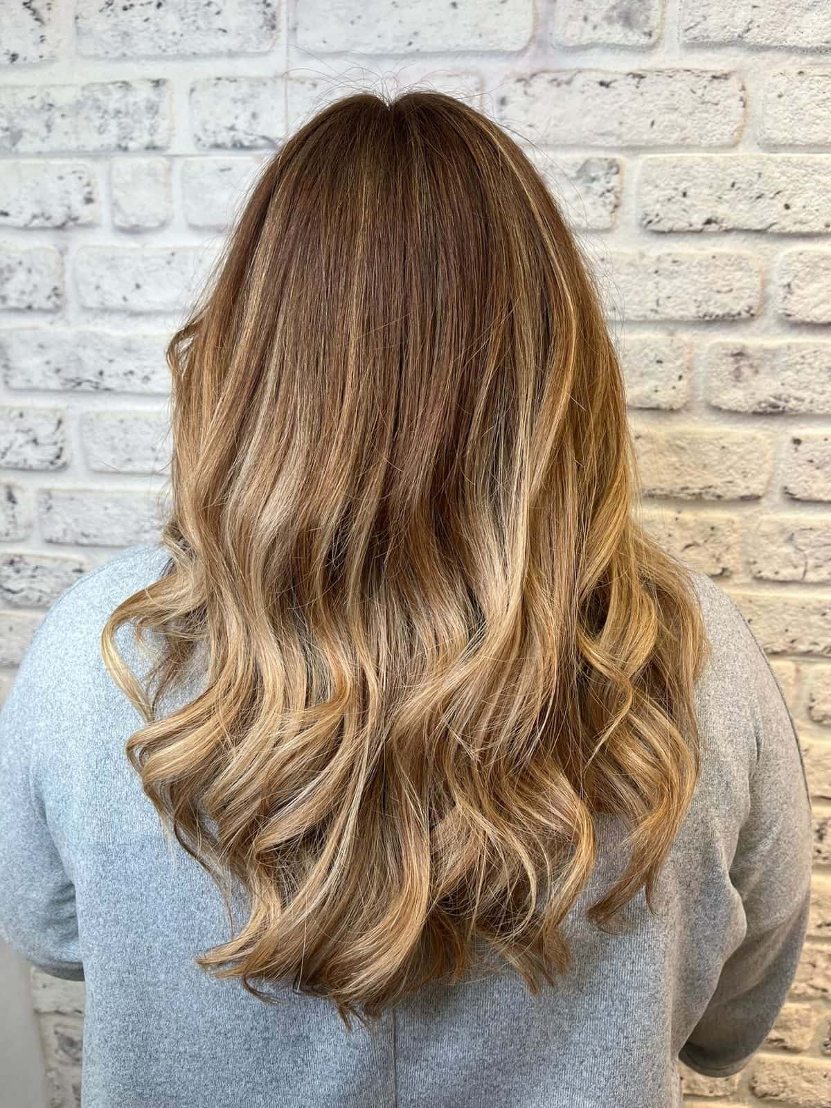 Scattered blonde highlights styled into waves at The Establishment Hairdressing, Farnham